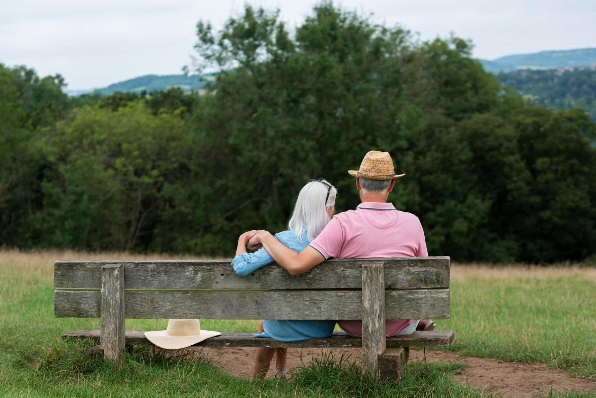 photo of a couple sitting on a bench overlooking fields during a relaxing English countryside escape