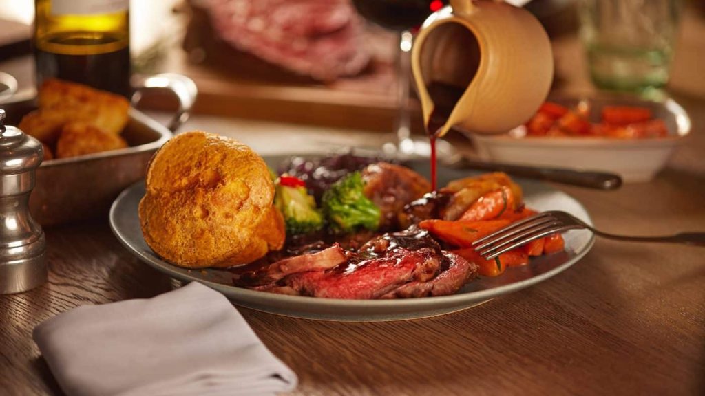 photo of rich gravy being poured over a traditional British roast dinner