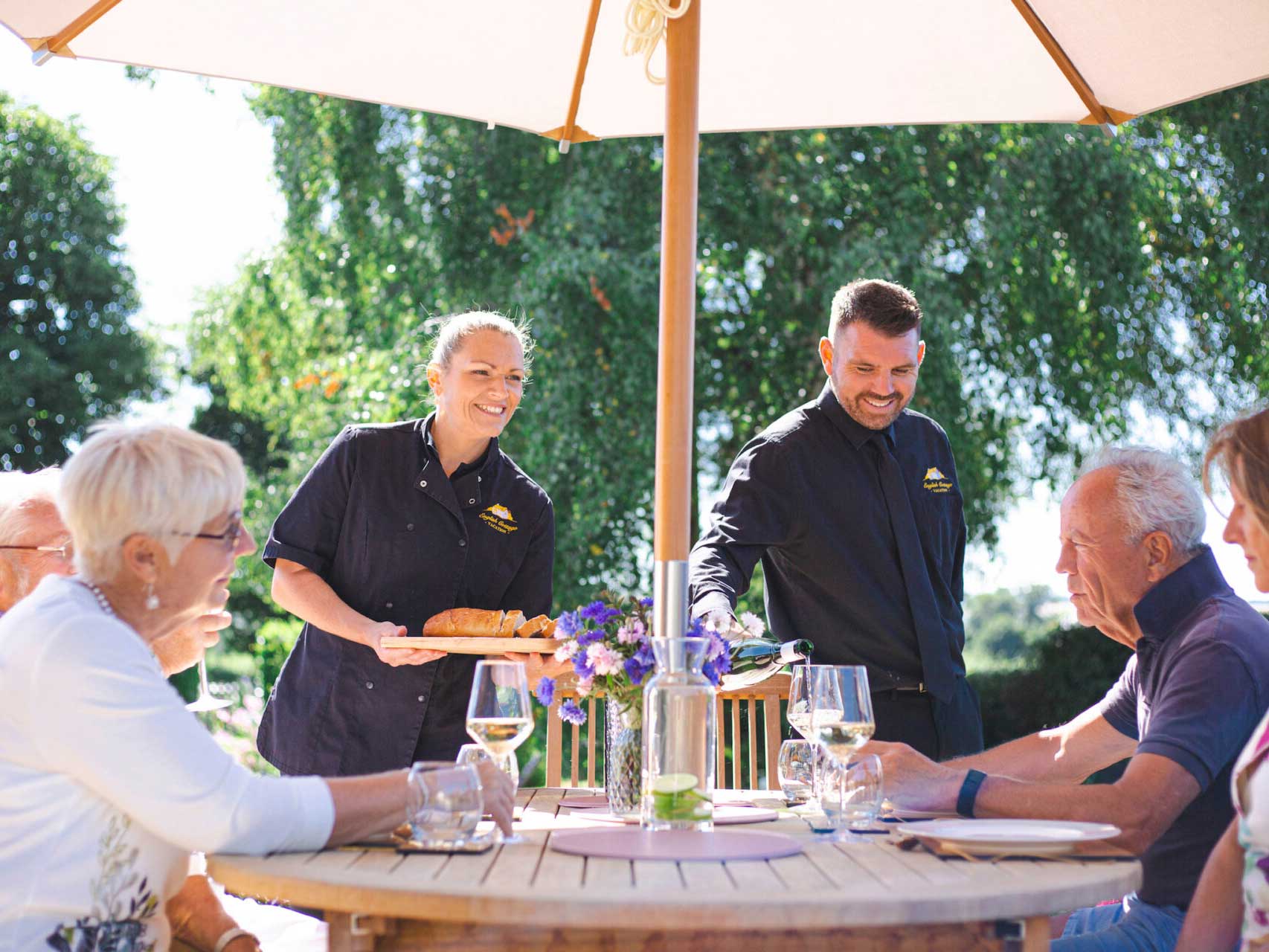 Eating-outside-at-English-Cottage-Vaccation photo of Laura and Nathan serving guests in the garden