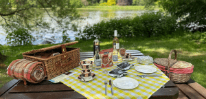 picnic basket and table set up beside a lake
