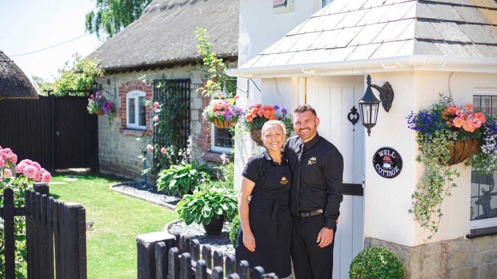 laura-nathan-wellcottage-welcome photo of Laura and Nathan in front of Well Cottage