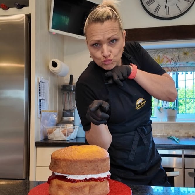 photo of Laura in her kitchen with a cake she baked