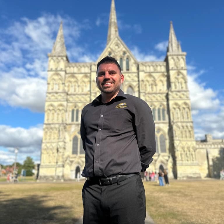 photo of Nathan standing in front of the Salisbury Cathedral